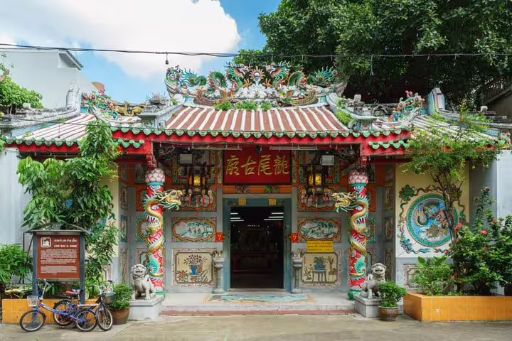 Colorful Chinese temple entrance with dragon sculptures and ornate roof in Bangkok Chinatown