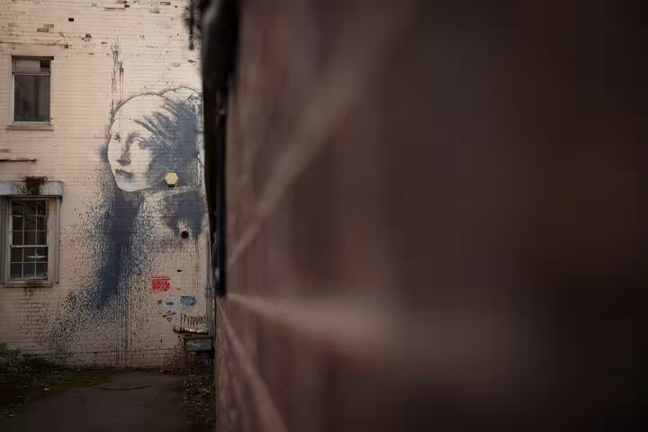 Banksy Girl with the Pearl Earring mural on a Bristol building wall