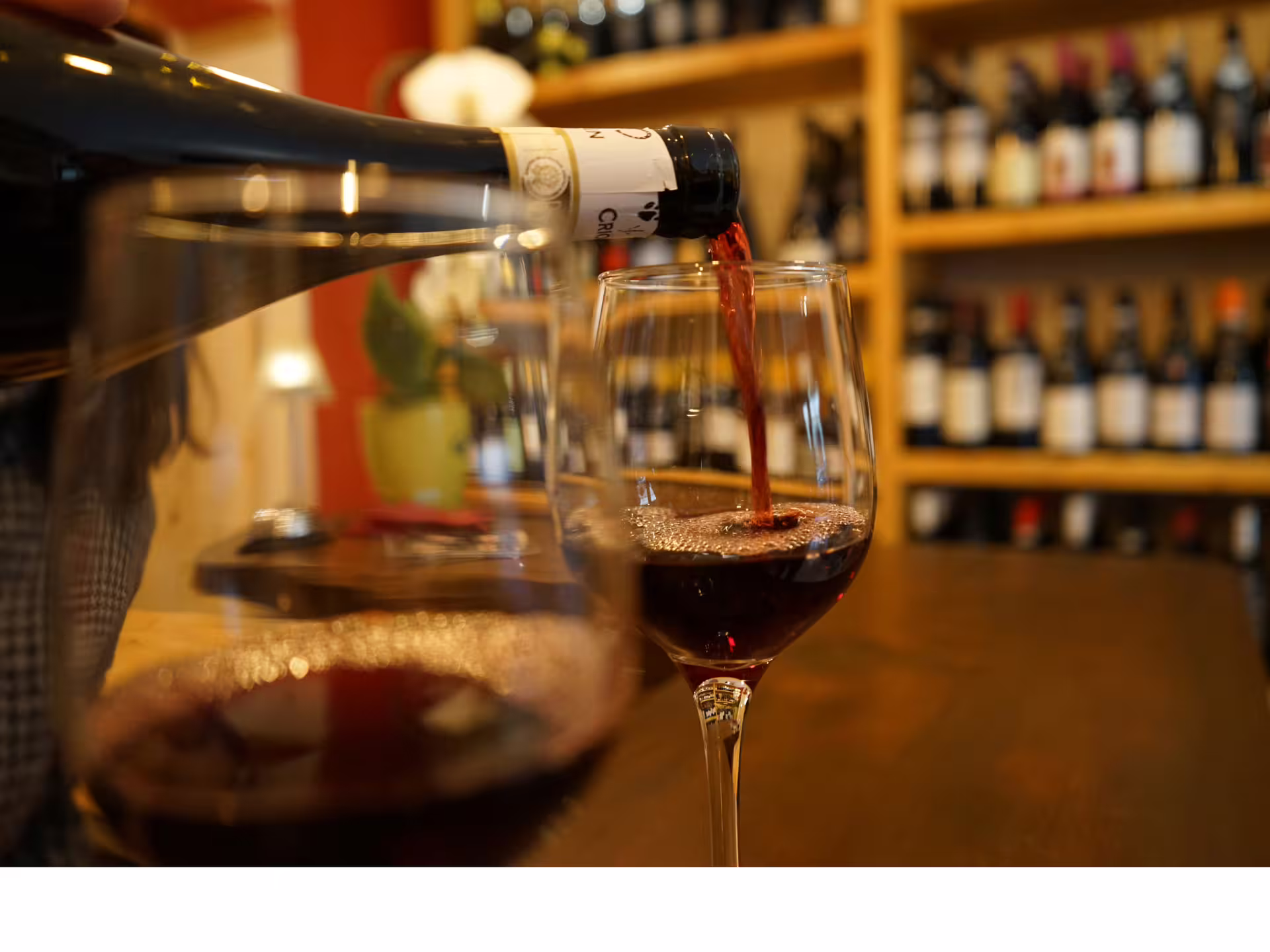 Close-up of Barbera red wine being poured during Turin city center wine tasting tour in a cozy local enoteca