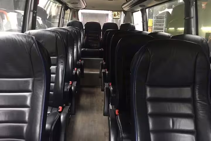 Spacious interior of a private transfer minibus from Barcelona city to airport, seating up to 15 people comfortably.