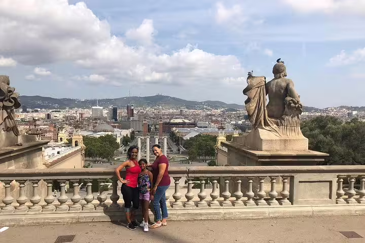 Family posing on Montjuïc terrace with panoramic views of Barcelona's skyline, perfect for a Gothic Quarter, Sagrada Familia, and Park Güell tour.