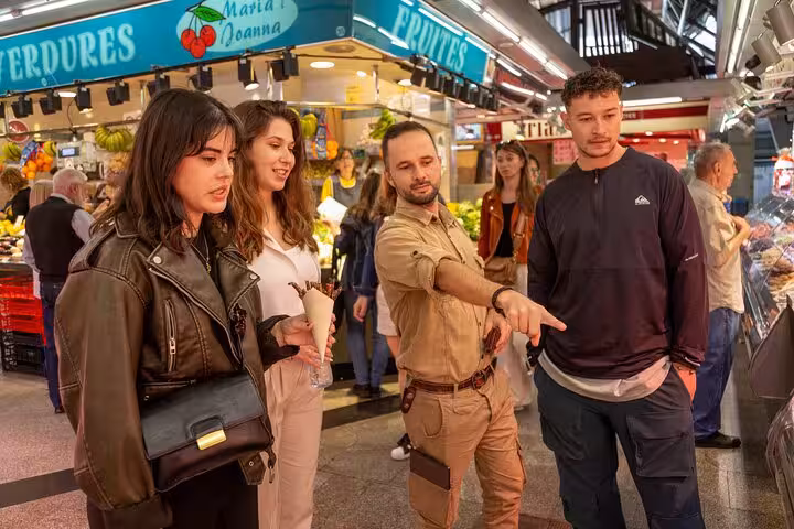 Guide leading a Barcelona small group food tour through La Boqueria Market, exploring fresh produce stalls