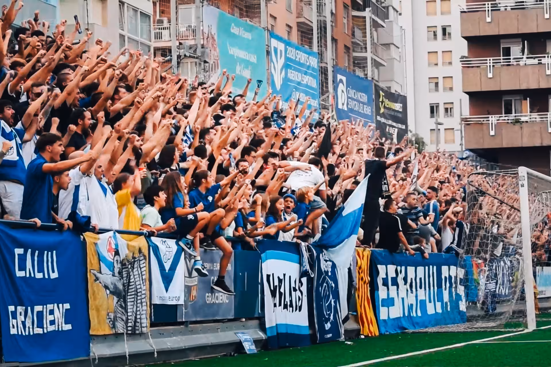 Fans cheering in packed stands at a Barcelona football match, capturing the city’s vibrant supporter culture