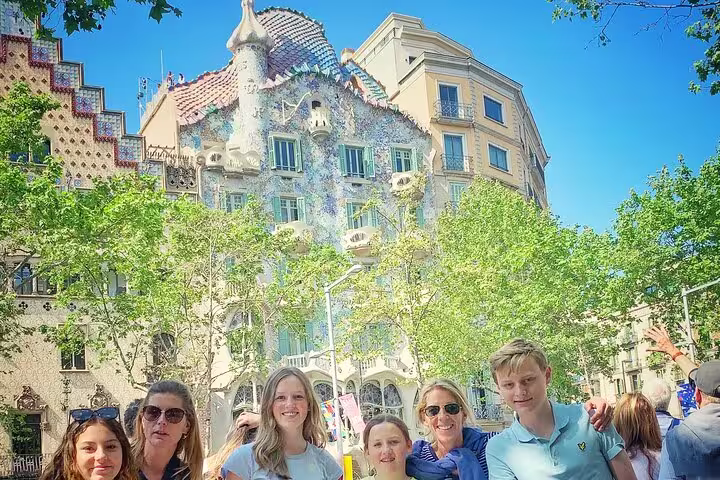 Tourists posing in front of Casa Batlló, a stunning Gaudi masterpiece, during a Barcelona highlights tour.