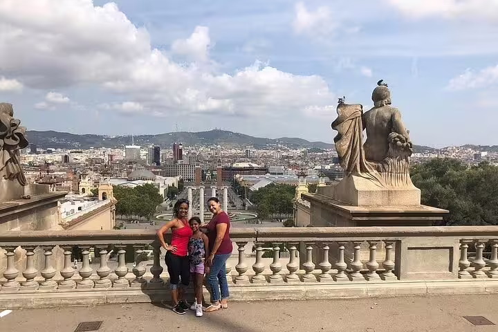 Family posing with panoramic views of Barcelona from a historic vantage point, part of the VIP private tour.