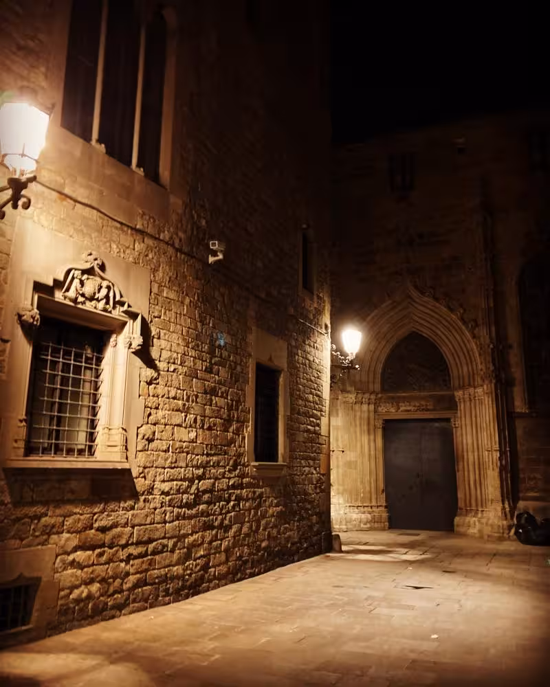 Night view of a mysterious Gothic alley in Barcelona, showcasing medieval architecture for a legends tour.