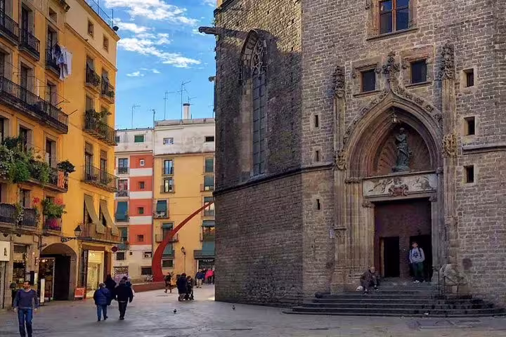 Charming Gothic Quarter street with historic architecture and vibrant city life, perfect for a Barcelona walking tour.
