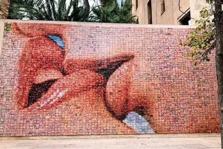 Mosaic mural of two people kissing on a wall in Barcelona's Gothic Quarter