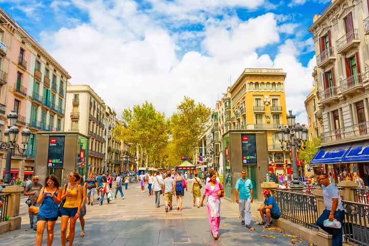 Busy pedestrian boulevard Las Ramblas in Barcelona's Gothic Quarter with historic buildings and tourists