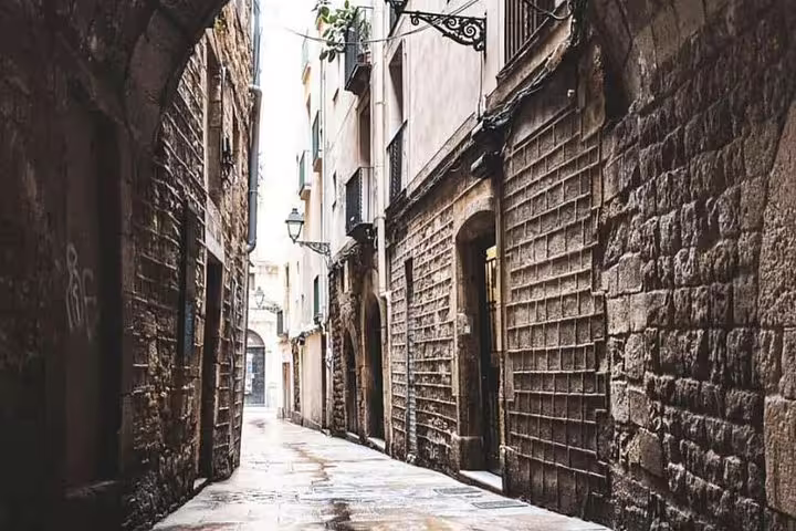 Charming narrow alleyway in Barcelona's Gothic Quarter showcasing historic stone architecture and archways.