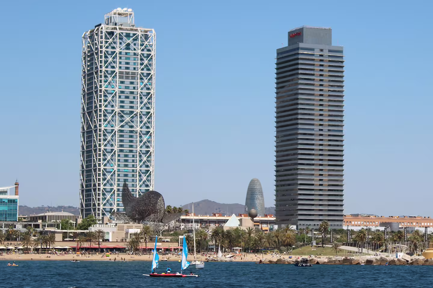 Barcelona skyline featuring iconic skyscrapers and beach, viewed from the sea during the Gothic Quarter boat trip.