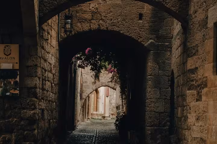Explore a charming stone archway in Barcelona's Gothic Quarter on a private full day tour by car.