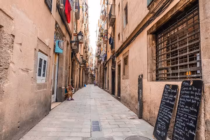 Narrow Gothic Quarter lane in Barcelona with tapas menu board, ideal stop on an authentic tapas and wine tour