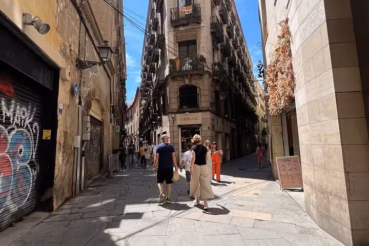 Tourists strolling through vibrant streets of Barcelona's Gothic Quarter, exploring local shops and architecture.