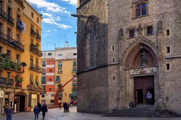 Historic Barcelona square with Gothic church facade and colorful buildings on a private Gaudi tour