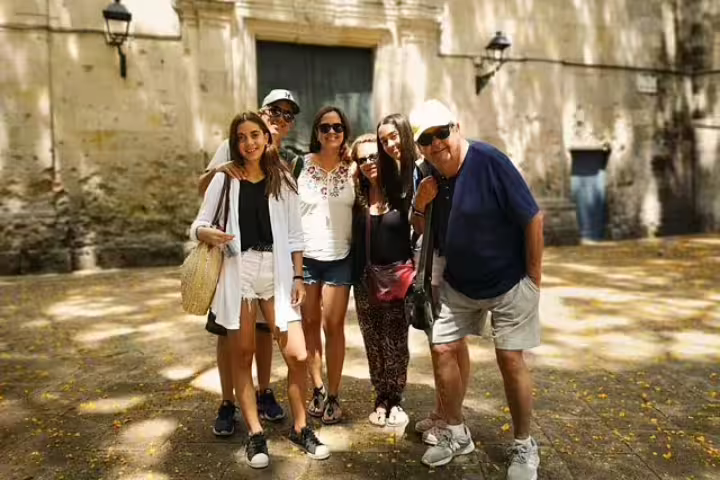 Group enjoying the Barcelona Highlights & Secrets Private Tour, standing in a sunlit historic plaza, perfect for exploring local culture.