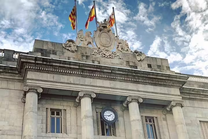 Historic building with flags and clock in Barcelona, featured on the Private Walking Tour with Flamenco Show.