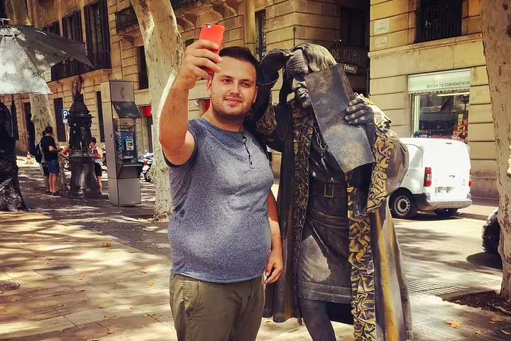 Tourist taking a selfie with a living statue on La Rambla, Barcelona, capturing vibrant street culture on a private city tour.