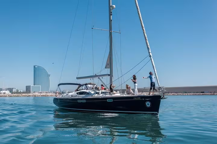 Private luxury sailboat near Barcelona coastline with W Hotel in view, exclusive sailing tour for small groups up to 12