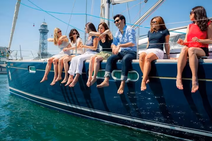 Friends relaxing with feet over the side on a Barcelona luxury sailboat, private sailing tour max 12