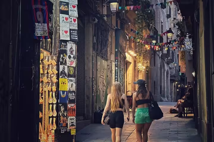 Two women exploring a charming narrow street in Old Town, adorned with colorful banners and vibrant storefronts.