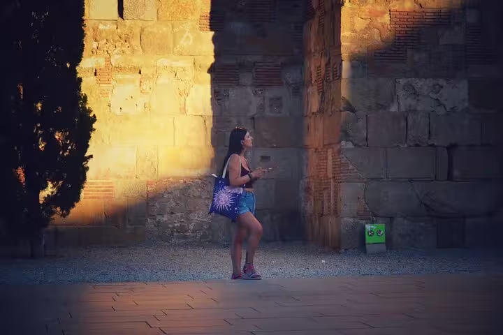 Two friends walking with a bicycle through the illuminated alleys, exploring the historic Old Town on a private tour.