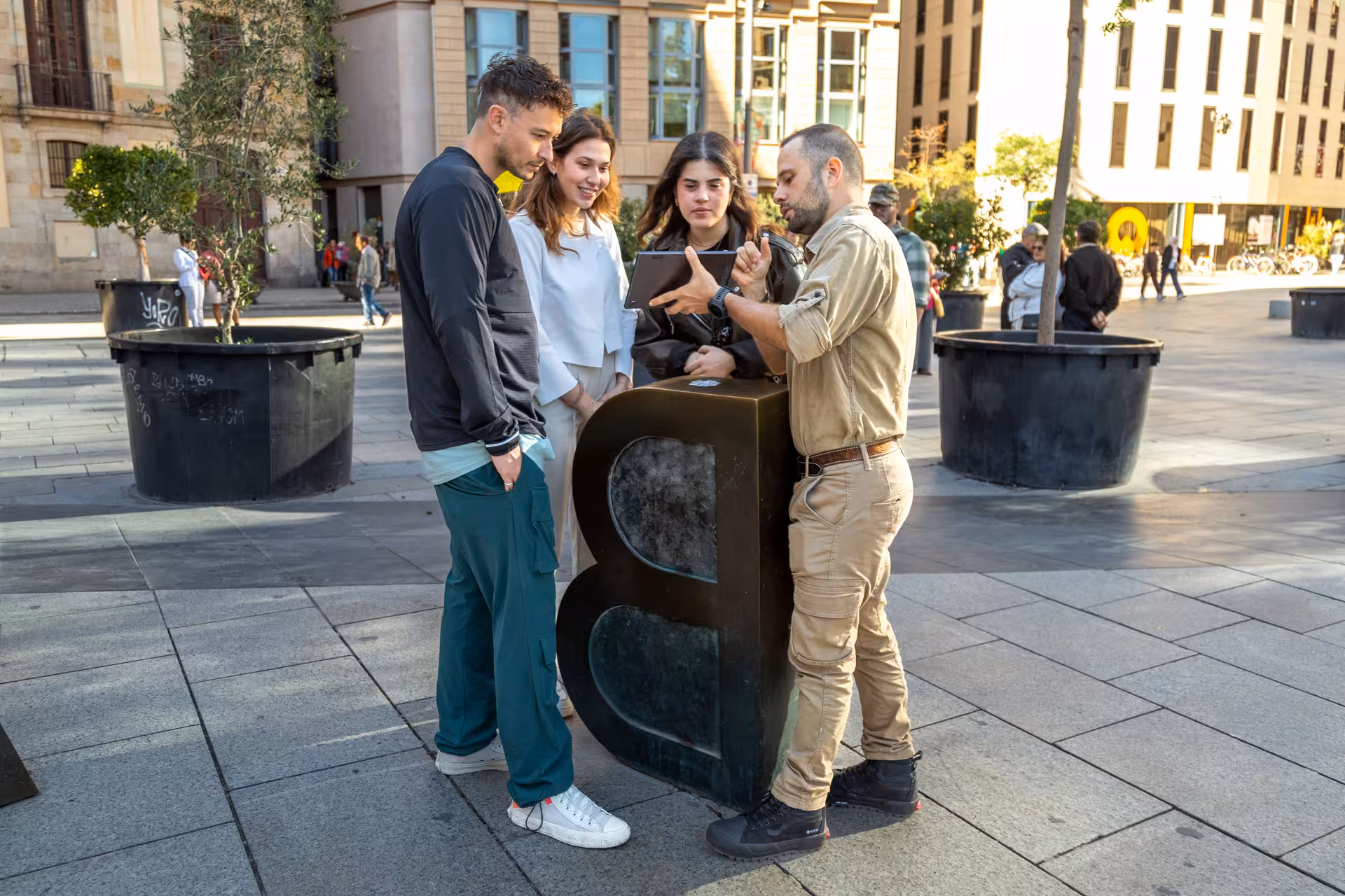 Barcelona Old Town guided tour meeting point, local guide showing route on tablet in city square