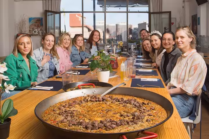 Group enjoying a freshly made paella at a Barcelona cooking class, showcasing authentic Spanish cuisine.