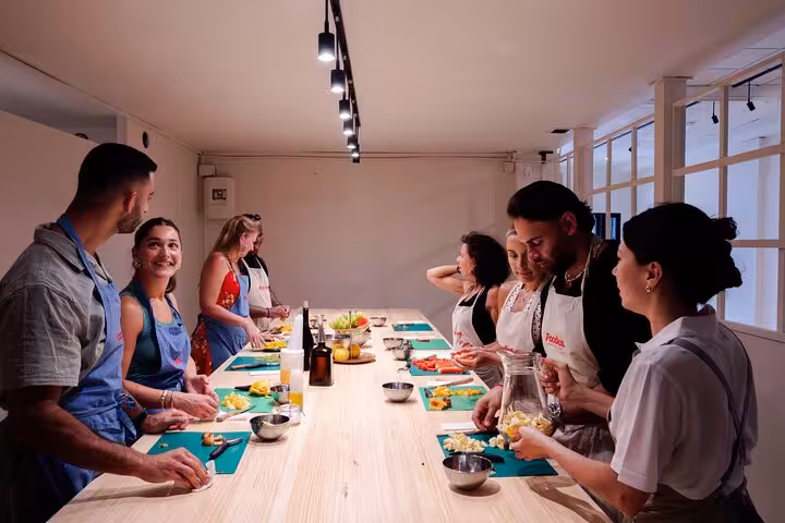 Group of diverse individuals enjoying a hands-on paella and sangria cooking class in Barcelona.