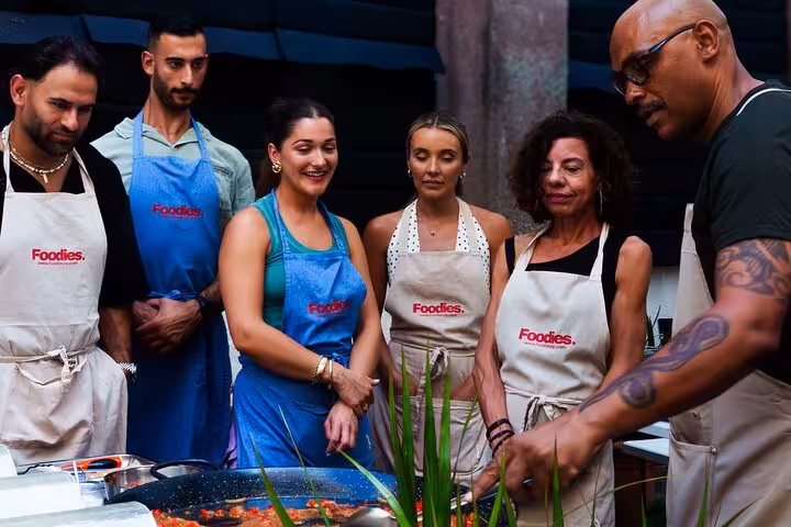 Group of people enjoying a hands-on paella and sangria cooking class in Barcelona, led by a local chef.