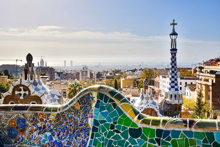 Colorful mosaic bench with panoramic views of Barcelona cityscape from Park Güell, featured in a private day tour.