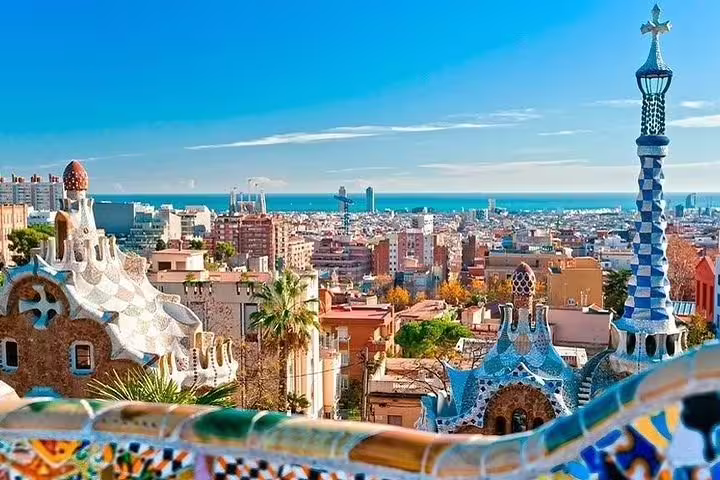 Panoramic view of Barcelona skyline from Park Güell, featuring colorful architecture and Mediterranean Sea.
