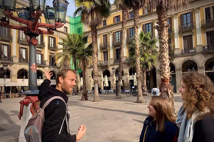 Tourists enjoy a guided experience at Plaça Reial, capturing the lively atmosphere and historic architecture of the Old Town.