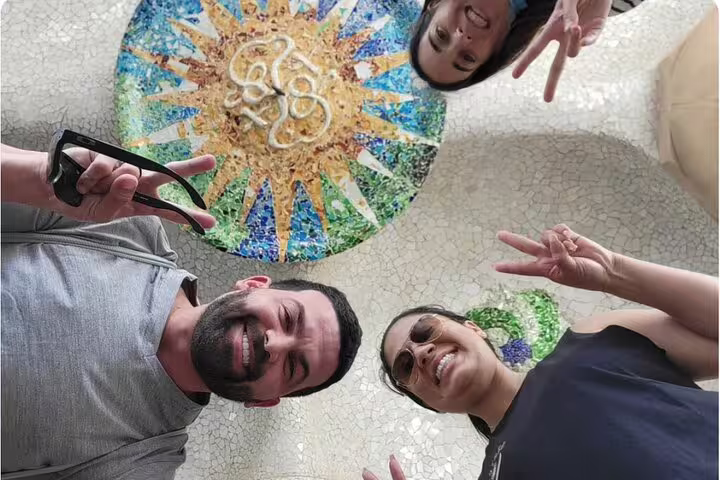 Tourists enjoying Gaudí's mosaic art at Park Güell during a Barcelona Premium tour of Gothic, Montjuic, and Sagrada Familia.
