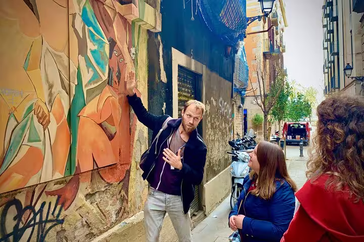 Guide explains vibrant street art to tourists on a walking tour of Barcelona's Ramblas.