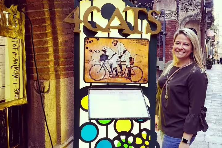 Smiling tourist outside 4 Cats restaurant in Barcelona, enjoying a private tour including Sagrada Familia, Park Guell, and tapas.