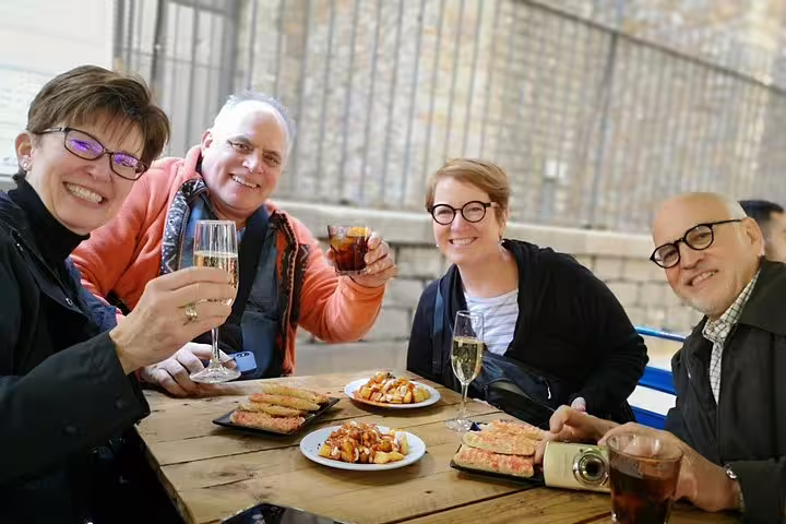 Group enjoying tapas and drinks during a Barcelona private tour, featuring Sagrada Familia and Park Guell experiences.