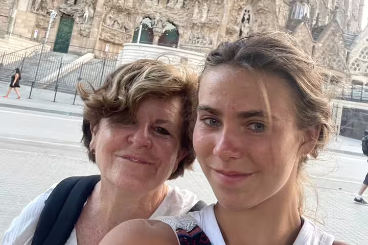 Two visitors pose by Sagrada Familia during a Barcelona self-guided scavenger hunt and walking tour