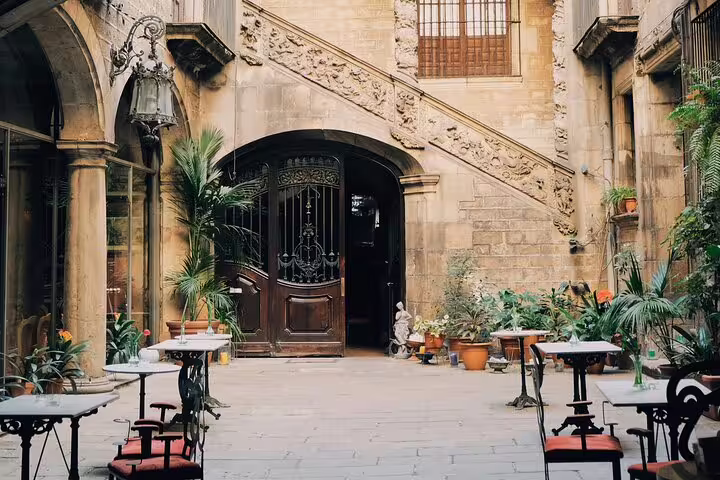 Charming courtyard with historic architecture and cafe tables in Barcelona, featured on private city tour.