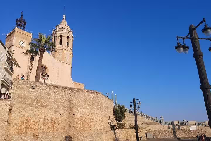 Historic church and vibrant blue sky in Sitges, showcasing stunning architecture on a Barcelona-Sitges tour.