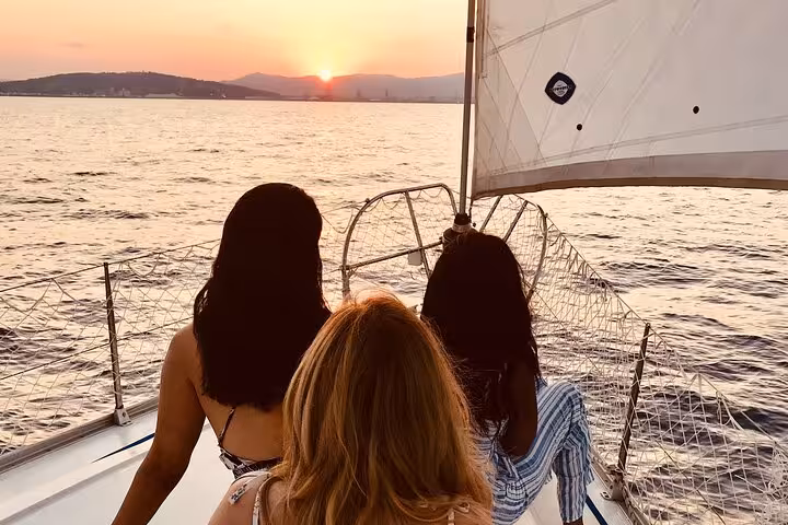 Guests relax on a private sailboat at sunset in Barcelona, enjoying open bar and live Spanish guitar