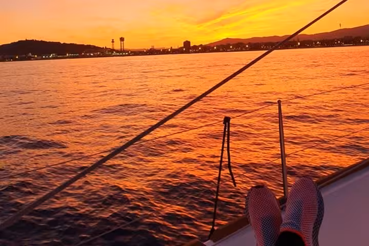 Relaxing on deck during a Barcelona sunset private sailing cruise, golden sea views with open bar and snacks