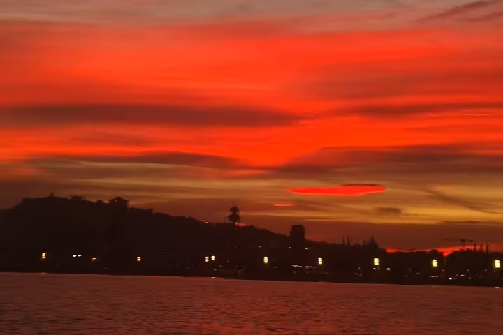 Fiery Barcelona sunset over the Mediterranean seen from a private sailing cruise, perfect for live saxophone vibes