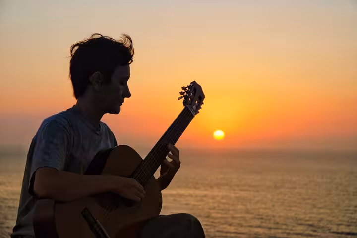 Live Spanish guitar at sunset on a private Barcelona sailing tour with open bar, Mediterranean sea views