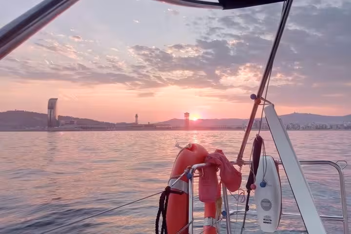 Barcelona sunset sailing tour view from the yacht with lifebuoy, calm sea, and skyline beyond