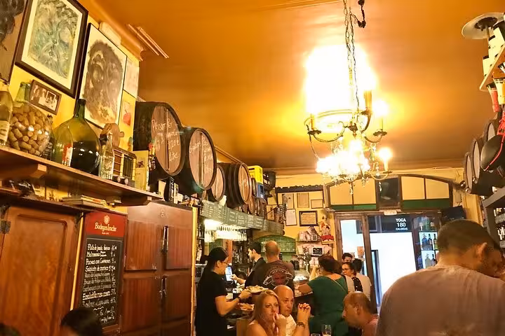 Bustling Barcelona tapas bar interior with locals enjoying authentic tapas and wine tasting on a guided tour