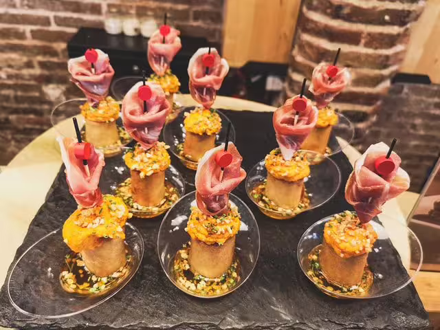 Traditional Spanish tapas with cured ham and savory toppings displayed in a rustic Barcelona tavern setting for a wine tour.