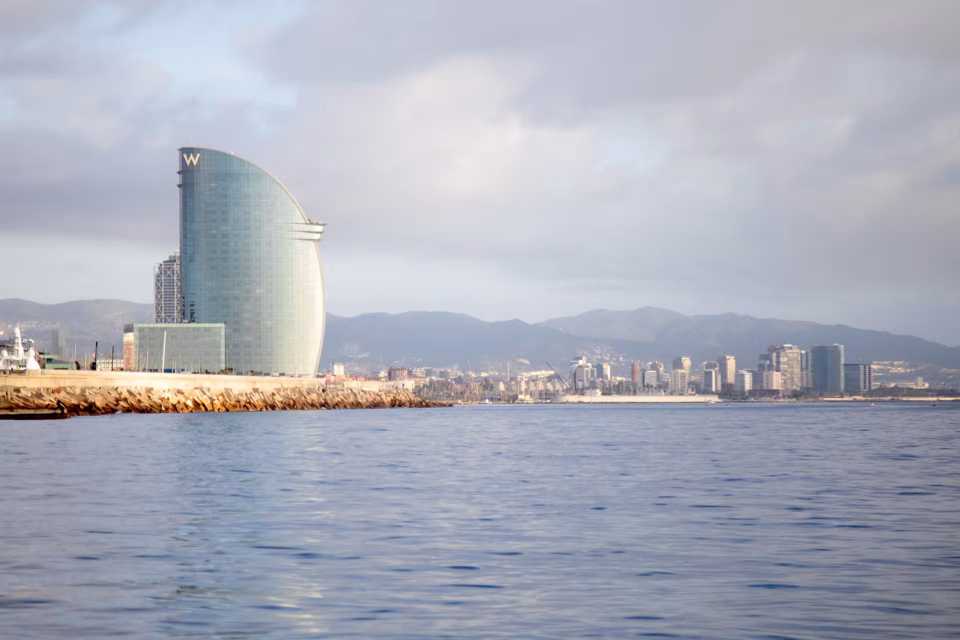 Barcelona waterfront view with W Hotel in background, perfect seaside setting for a romantic marriage proposal