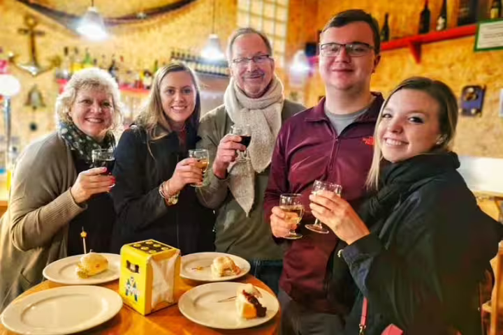 Group enjoying wine and tapas in a cozy Barcelona tavern during a private food and drink tour, showcasing authentic local flavors.