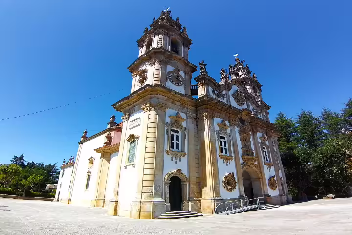 Baroque church in Lamego under a clear blue sky, showcasing intricate architecture on a private tour of the Dão wine region.